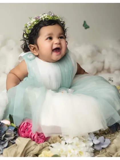 Celebrating six months of pure magic. This little one's happy expression is captured in a dreamy setup with soft clouds and a floral crown. My six-month milestone sessions are designed to showcase your baby's budding personality and those adorable gummy grins.
