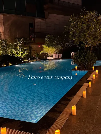 The poolside is set with a simple yet romantic line of electronic candles along the edge, building anticipation for the main decoration.