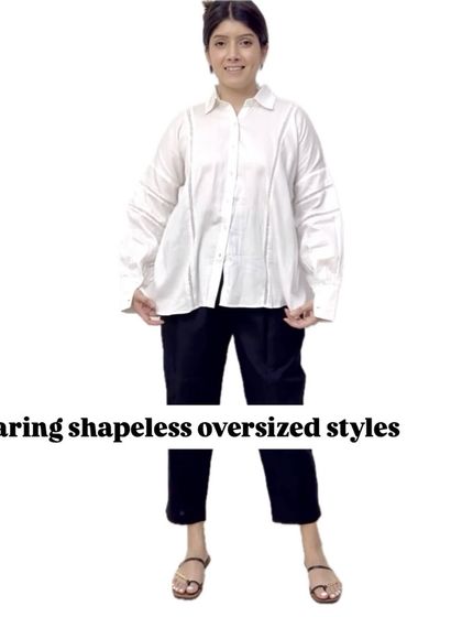 A clear "don't" for postpartum styling. Wearing shapeless, oversized styles like this large white shirt can actually add bulk and hide your figure entirely.