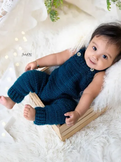 Relaxing in a little wooden crate, this baby boy's sweet smile lights up the whole photo. The simple props complement his adorable blue outfit.