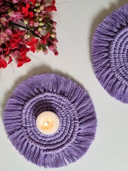 A pair of my lavender macrame coasters, one with a candle and one without, showing their versatility.