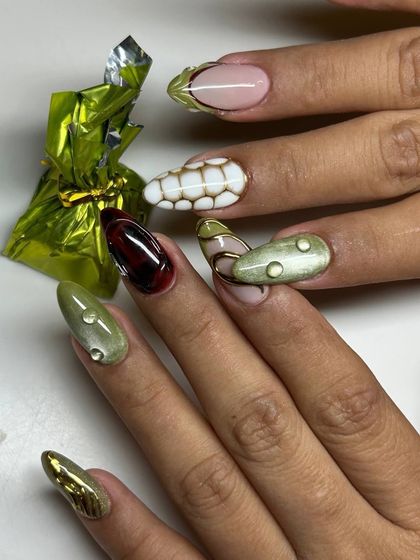 A full view of a unique, nature-inspired nail art set. The design incorporates various textures and 3D elements, like water droplets and abstract patterns, in shades of green, brown, and nude.
