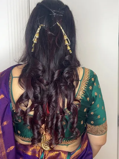 A closer look at the hairstyle I created for Anita. I used decorative hairpins to add a touch of gold to her soft curls, matching her jewelry perfectly.