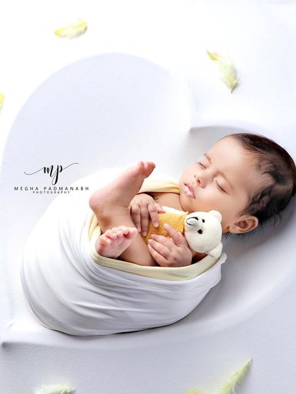 A side view of the baby snuggling his teddy bear, a memory to cherish.