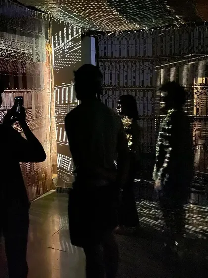 The students' silhouettes against the projected light patterns of the installation.