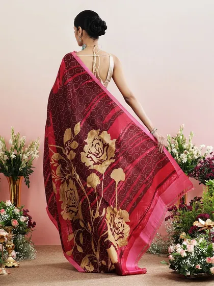 The back of this saree reveals a stunning pallu with large, golden rose prints against a deep red background. It is a piece of printed poetry.