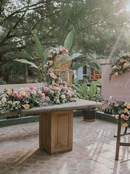 The welcome table features a stunning cascading floral arrangement and a custom sign.