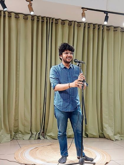 A host smiles at the crowd, setting a welcoming tone for the evening's performances.