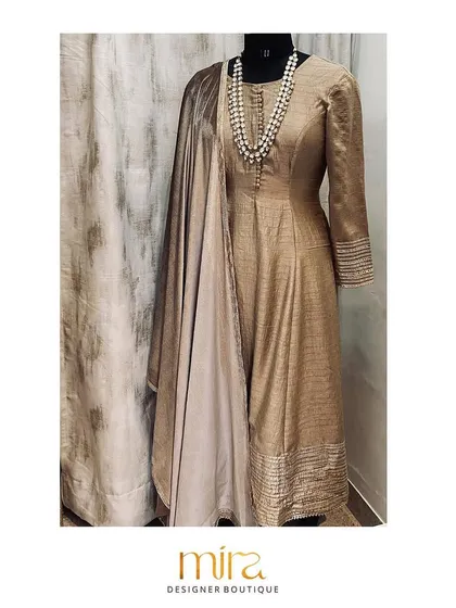 An elegant flared raw silk kurta set in a subtle earthy tone. Paired with a velvet dupatta featuring gotta patti work, this outfit is a sophisticated choice for an intimate pre-wedding event or puja.