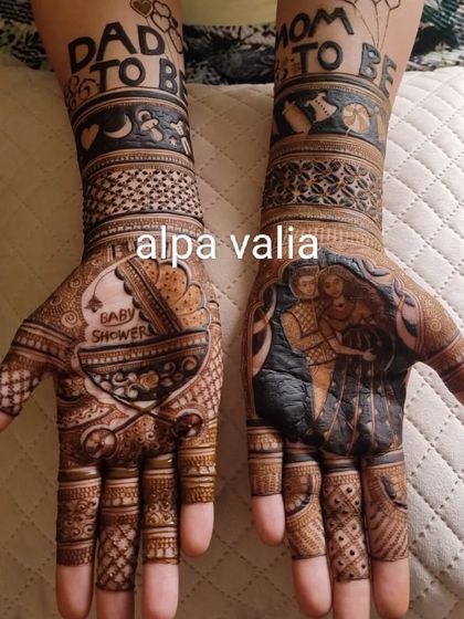 This baby shower mehendi features "Dad to be" and "Mom to be" on the arms, with a baby cradle and a portrait of the couple.