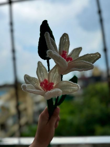Our handmade crochet lilies against a beautiful sky. These flowers are perfect for photos and will never wilt or fade.