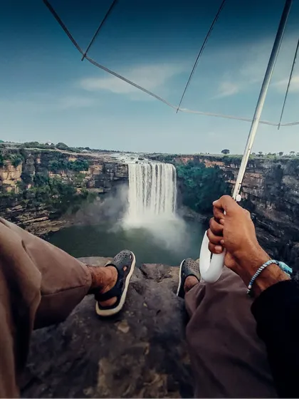 A first-person perspective of sitting at the edge of a cliff, looking out at a magnificent waterfall in Madhya Pradesh. A reminder that passion matters more than expensive gear.