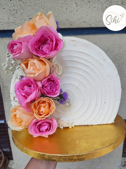 This top-forward cake design really puts the flowers in the spotlight. The textured buttercream provides a beautiful canvas for a cascade of fresh pink and peach roses, creating a modern and artistic centerpiece.