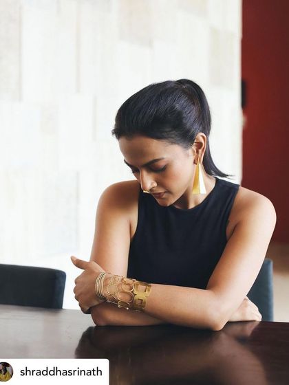 Another angle of the promotional look for Shraddha Srinath, showing the clean lines of the dress and the powerful statement made by the cuff bracelet.