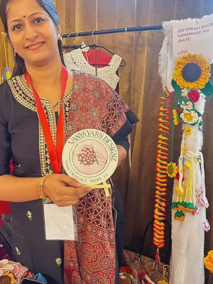 Here I am at my stall, holding my brand logo, surrounded by my colorful creations. I'm so proud to be a part of the handmade community.