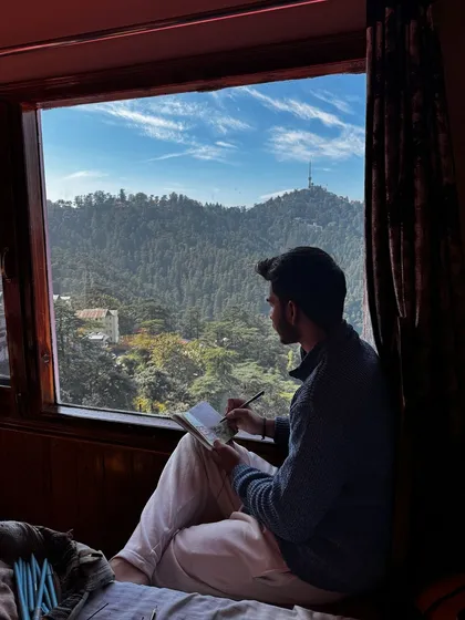 Finding a moment of peace by the window to sketch a mountain landscape. Sometimes, all it takes is a sketchbook and a pen to capture the feeling of a place, whether it's a grand view or a quiet corner of your home.
