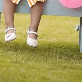 It's all about the little details. This close-up shot from an outdoor birthday session focuses on the tiny shoes, a sweet memory of how small they once were.
