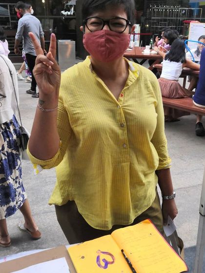 A happy visitor at my art stall, ready to dive into a creative session. I always keep a guestbook for people to share their thoughts and experiences.