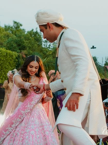 The groom lovingly takes his bride's hand as she steps onto the stage. It's a small gesture of support and partnership that marks the beginning of their journey together.