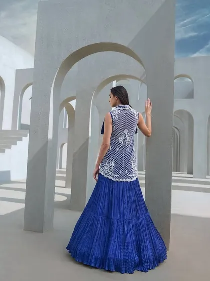 A modern ensemble featuring a pearl-embellished top with oversized lapels, paired with a crushed skirt in Active Blue. This look doesn't follow trends, it makes statements.