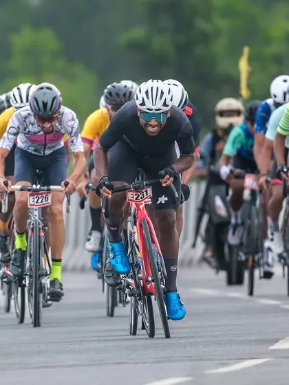 An elite rider, followed by a support moto, attacks on the highway, trying to break away from the pack.