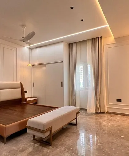 A bedroom suite featuring our custom bed with a two-tone upholstered headboard and a sleek bench with a metal frame. Each piece is crafted to match the home's modern architecture and the client's personality.