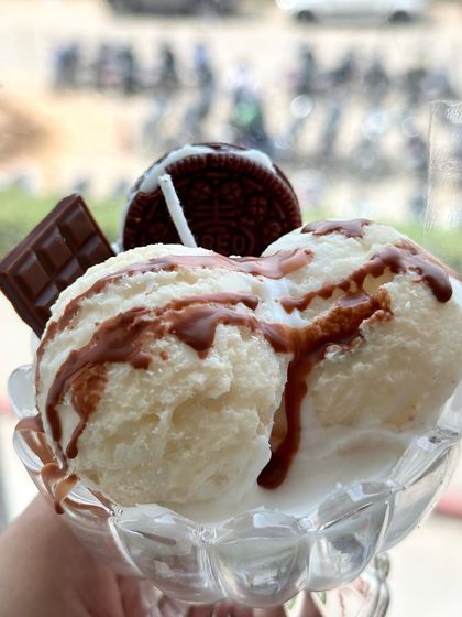 The Vanilla Ice Cream Sundae soy candle, featuring vanilla scoops, chocolate sauce, a wax chocolate bar, and an Oreo. It's a crazy, tempting creation in a real glass bowl.