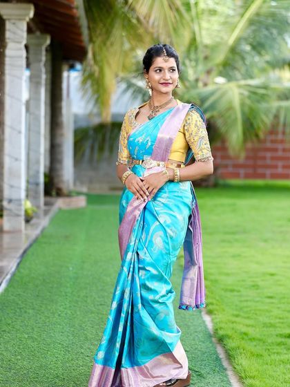 A full-length view of Kavya's engagement attire. The bright blue Kanchipuram silk stands out beautifully, making it a perfect choice for a memorable pre-wedding celebration.