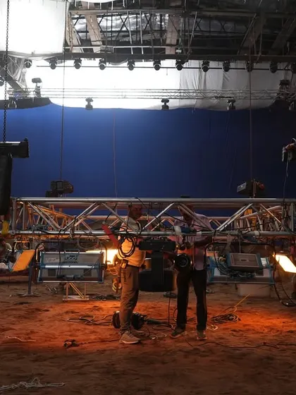 The crew setting up a shot on the sandy floor of the 'Uyi Amma' set, with our extensive lighting rig visible above.