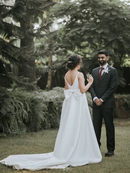 The couple sharing their private vows in a garden, a deeply personal and emotional moment.