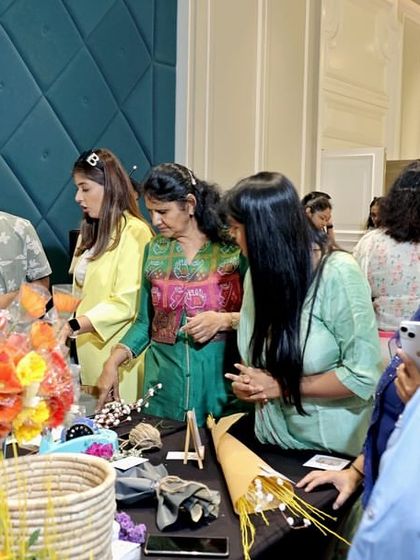 Guests exploring a vibrant floral and craft stall at one of my social events. I love to support local artisans and provide my guests with unique shopping opportunities as part of the overall event experience.