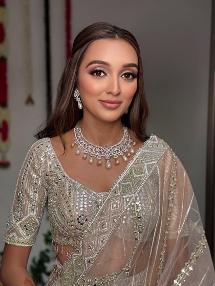 A close-up portrait of the client. The simple half-up style with a center part is modern, chic, and incredibly flattering.