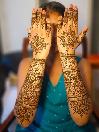 A playful pose showing off a full bridal set, featuring geometric diamond patterns on the back of the hands.