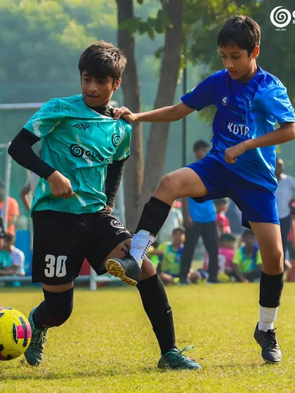 A tough tackle between two players, both determined to win the ball for their team.