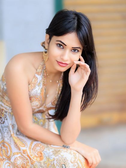 A charming and relaxed seated portrait. Her gentle smile and natural pose make this a warm and inviting image.