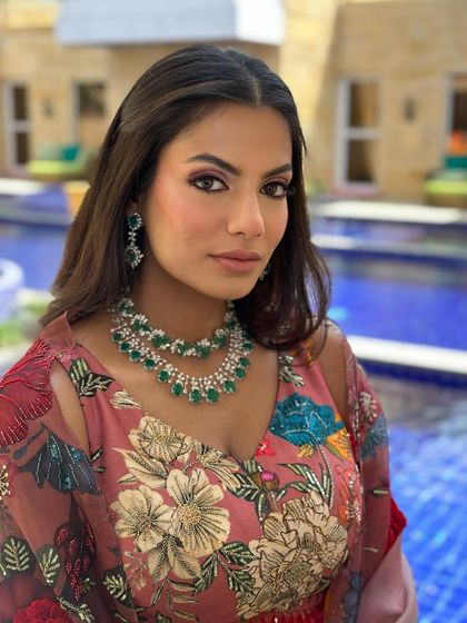 A beautiful poolside look for a Mehendi. The makeup is a soft smokey eye with a nude lip, complementing the floral Varun Bahl outfit.