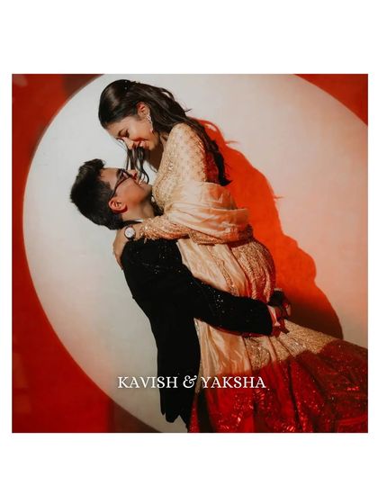 A dramatic and romantic lift against a spotlight. This studio-style shot adds a touch of cinematic flair to the couple's pre-wedding album, highlighting their chemistry.