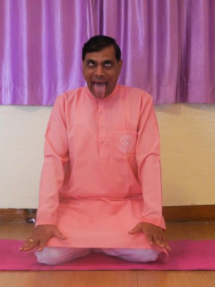 A practitioner demonstrates Simhasana (Lion's Pose), a unique asana that involves a forceful exhalation. It is known to relieve tension in the face and jaw and is often practiced to build confidence.