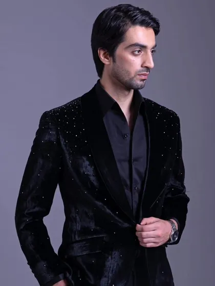 Another angle of the embellished black velvet jacket, showing how it catches the light. It's an elegant choice for an evening event.