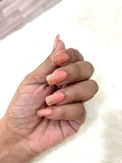 A close-up of the hand with these peach and gold glitter ombré nails. The square shape gives them a modern feel, while the glitter adds that essential bridal sparkle.