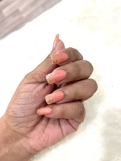A side profile of the peach and glitter nails, highlighting the length and shape of the extensions. So elegant.