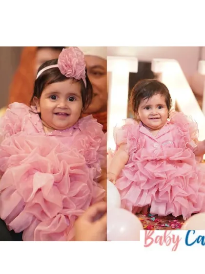 Ruffles for our little doll. This soft pink ruffled dress is all about texture and fun, designed to be as joyful and bubbly as the little girl wearing it. It's a perfect choice for a cake-smash photoshoot or a first birthday party.