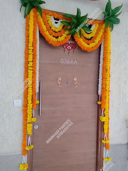 A traditional marigold and mango leaf toran for a main door, perfect for housewarmings, festivals, and pujas.