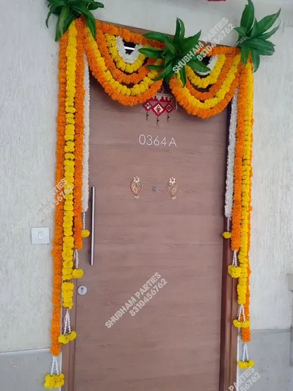 A traditional marigold and mango leaf toran for a main door, perfect for housewarmings, festivals, and pujas.