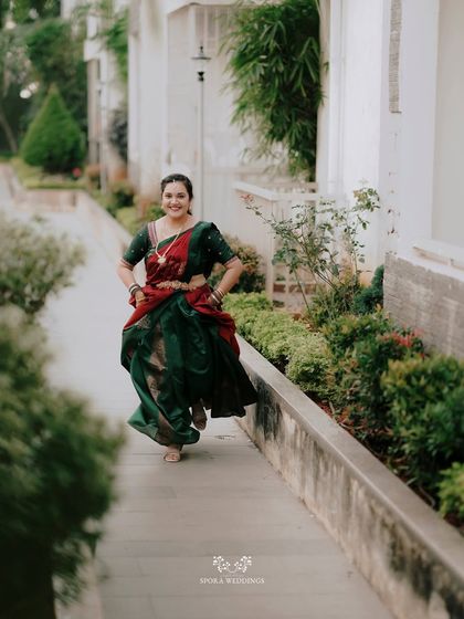 A joyful, energetic shot of the bride running playfully in her traditional half saree.