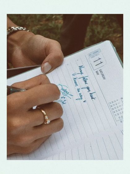 A close-up of my hand writing in a diary. A simple reminder to 'Always follow your heart, it knows the way'. This is the core of my writing practice.