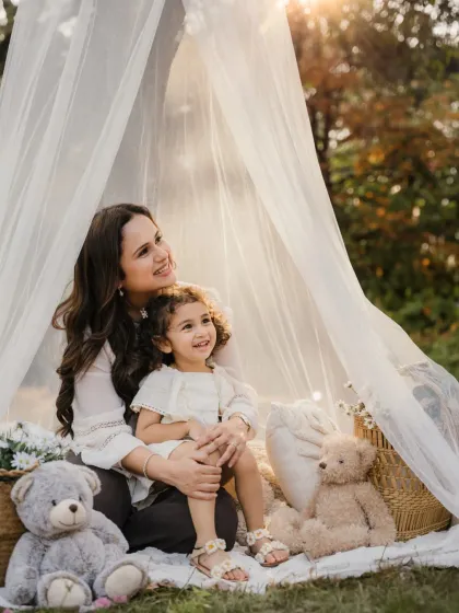 A mother and daughter look out from their teepee, enjoying the beautiful day. A lovely candid from an outdoor family session.