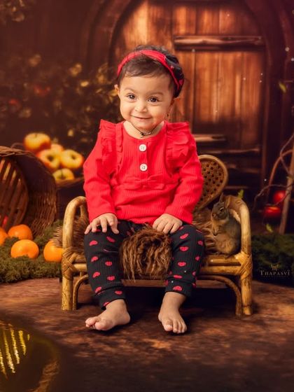 An autumn harvest theme with rich, warm colors, featuring a little girl sitting in a rustic, apple-filled scene.