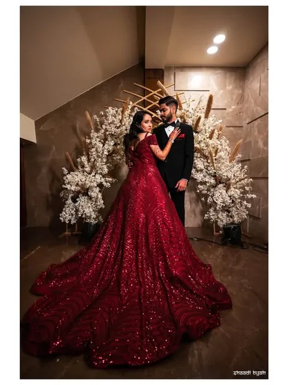 A vertical composition of the couple, emphasizing the grandeur of the bride's gown and the elegance of their pose.