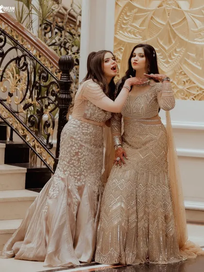 A playful moment between the bride Ekta and her sister Lekha on the grand staircase during the Roka festivities.
